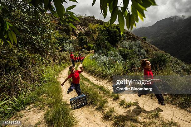 Bloomberg's Best Photos 2014: School children jump hurdles constructed of Pepsi crates during gym class at Culebrilla elementary school in...