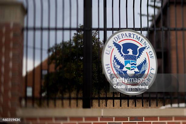 The U.S. Department of Homeland Security seal hangs on a fence at the agency's headquarters in this photo taken with a tilt-shift lens in Washington,...