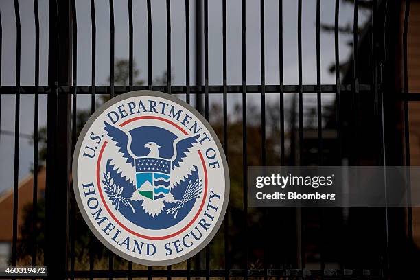 The U.S. Department of Homeland Security seal hangs on a fence at the agency's headquarters in Washington, D.C., U.S., on Thursday, Dec. 11, 2014....