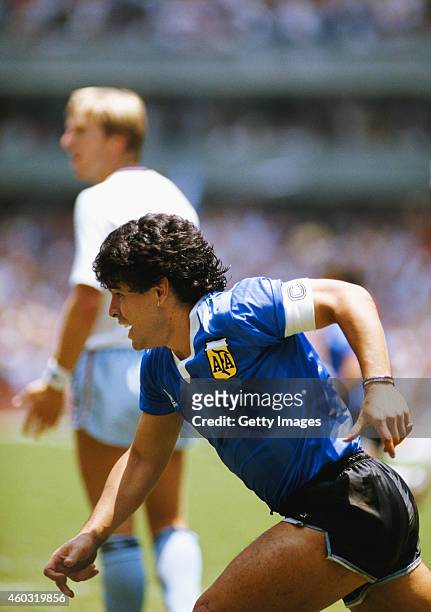 Diego Maradona of Argentina turns to celebrate after scoring the first goal as England defender Gary Stevens looks towards the linesman during the...