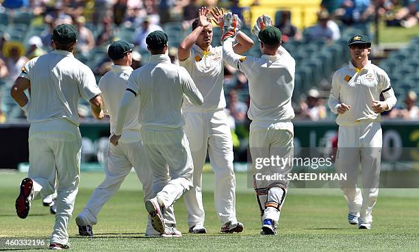 Australia's paceman Peter Siddle celebrates with teammates taking the wicket of India's Karn Sharma on the fourth day of the first Test cricket match...