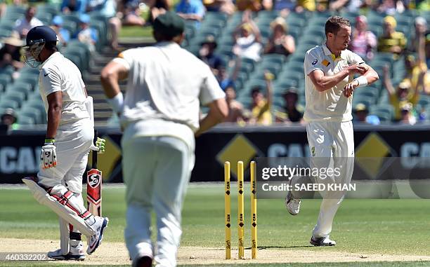 India's Karn Sharma leaves the crease after being clean bowled by Australia's paceman Peter Siddle on the fourth day of the first Test cricket match...