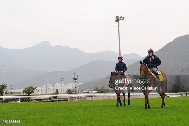 Melanie Sharpe riding Buffering and Andrea Atzeni riding Farraaj after galloping on the turf during a trackwork session at Sha Tin Racecourse on...