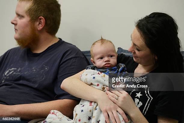 Mary Mascarenas holds her and Justin Johnson's newborn baby, Jason, while waiting for laundry to finish in laundry in the laundry room at the Almost...