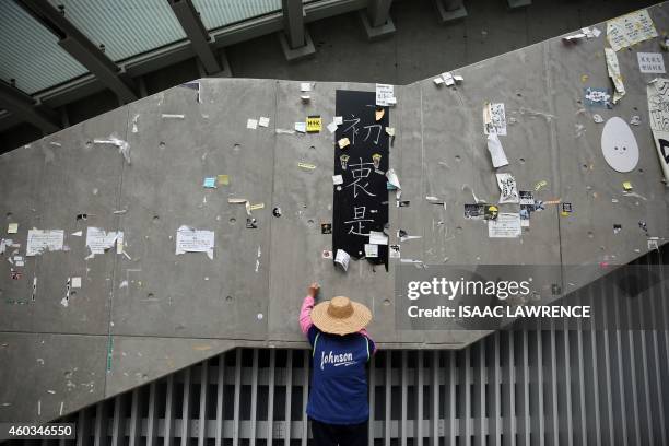 Worker cleans the area of the main pro-democracy protest site in the Admiralty district of Hong Kong on December 12, 2014. Rush-hour traffic streamed...