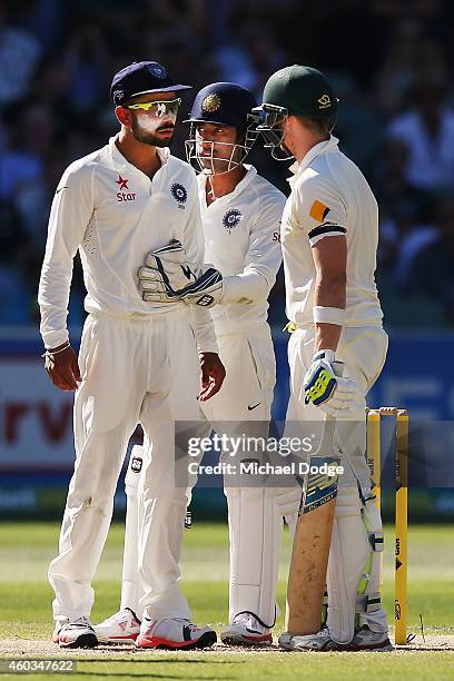 Virat Kohli of India is held back by keeper Wriddhiman Saha as he has words with Steve Smith of Australia after he padded away another ball from...