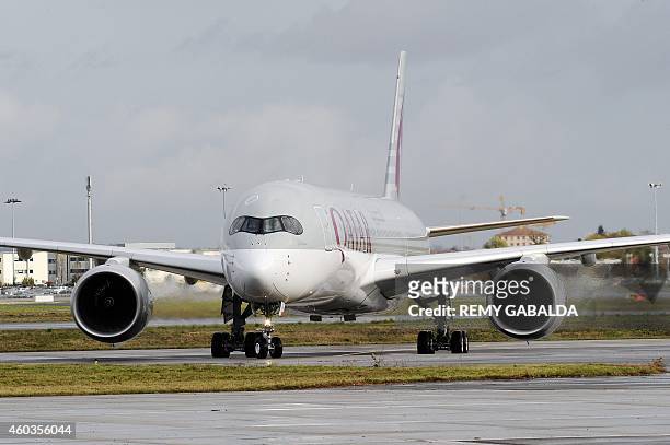 Photo taken on December 11, 2014 shows the first Airbus A350 bearing the Qatar airline company logo on the tarmac of Toulouse Blagnac airport. AFP...