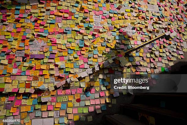 Commuter's shadow is cast on notes hanging on a wall outside the Central Government Offices in Hong Kong, China, on Thursday, Oct. 9, 2014. Hong Kong...