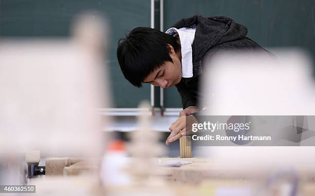 Refugee Luan from Vietnam who arrived in Germany without family members trains in wood-working techniques at a job-training center on December 12,...