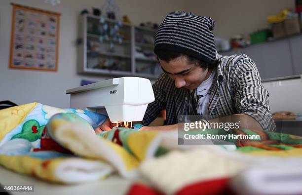 Refugee Diaa from Syria train in textile manufacturing at a job-training center on December 12, 2014 in Magdeburg, Germany. The refugees training...