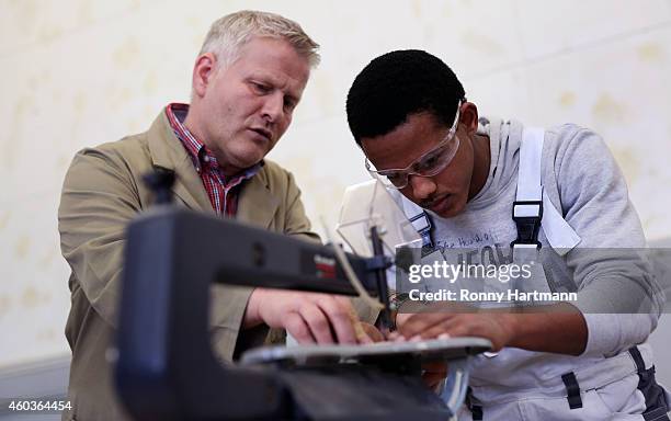 Refugee Merkawi from Eritrea who arrived in Germany without family members trains in wood-working techniques with training instructor Sven Parcek at...