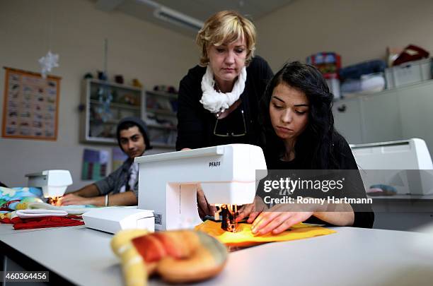 Refugee Domenika from Slovenia trains in textile manufacturing next to training instructor Silvia Huebner at a job-training center on December 12,...