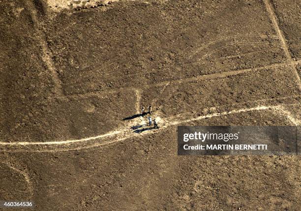 Members of the National Culture Institute of Peru evaluate damages at a millenia-old archaeological site after Greenpeace activists displayed a...