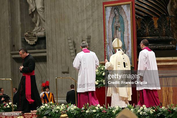 Pope Francis prays in front of a painting featuring Our Lady of Guadalupe in St. Peter's Basilica during an Eucharist celebration on December 12,...