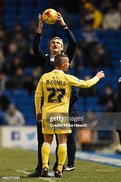 Brighton manager Sami Hyypia holds on to the ball as Scott McDonald of Millwall tries to retrieve it during the Sky Bet Championship match between...