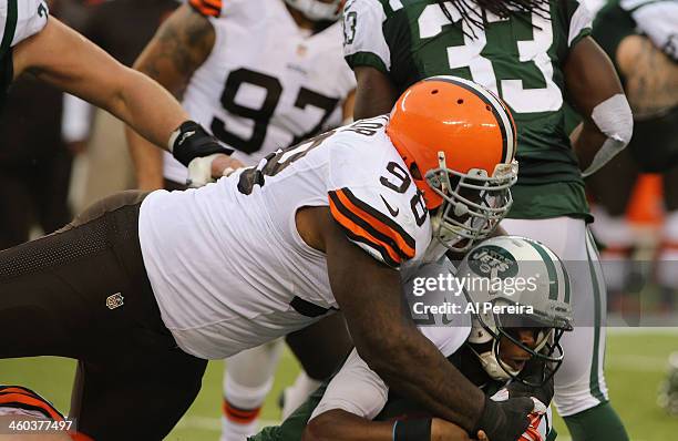 Quarterback Geno Smith of the New York Jets is tackled by Defensive Lineman Phil Taylor of the Cleveland Browns at MetLife Stadium on December 22,...