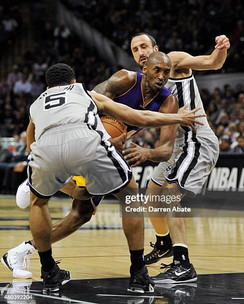 Guard Kobe Bryant of the Los Angeles Lakers drives through guards Manu Ginobili, right, and Cory Joseph, of the San Antonio Spurs, during the first...