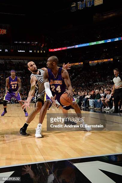 Kobe Bryant of the Los Angeles Lakers handles the ball against Manu Ginobili of the San Antonio Spurs on December 12, 2014 at the AT&T Center in San...