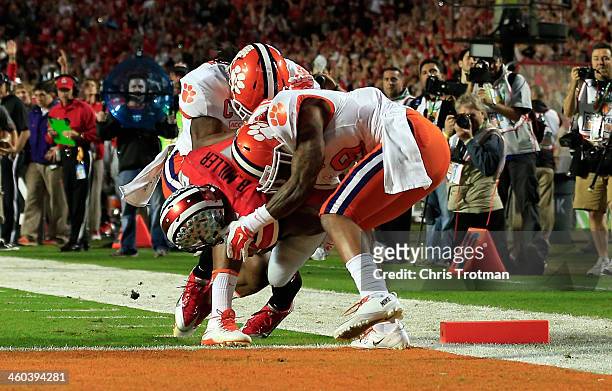 Braxton Miller of the Ohio State Buckeyes runs in for a touchdown in the first quarter against Quandon Christian and Darius Robinson of the Clemson...