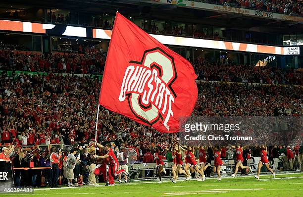 Cheerleader runs onto the field with an Ohio State Buckeyes flag prior to the Discover Orange Bowl against the Clemson Tigers at Sun Life Stadium on...