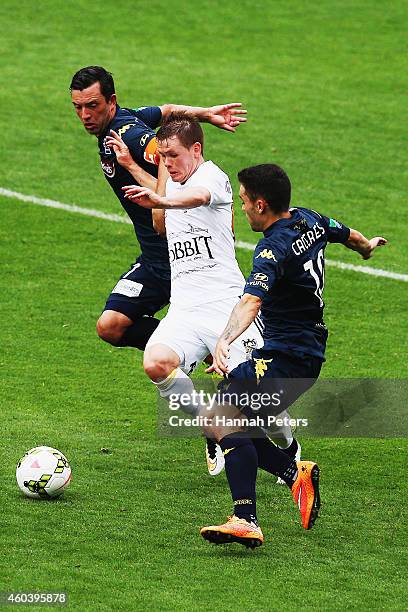 Michael McGlinchey of the Phoenix tries to get past John Hutchinson of the Mariners and Anthony Caceres of the Mariners during the round 11 A-League...