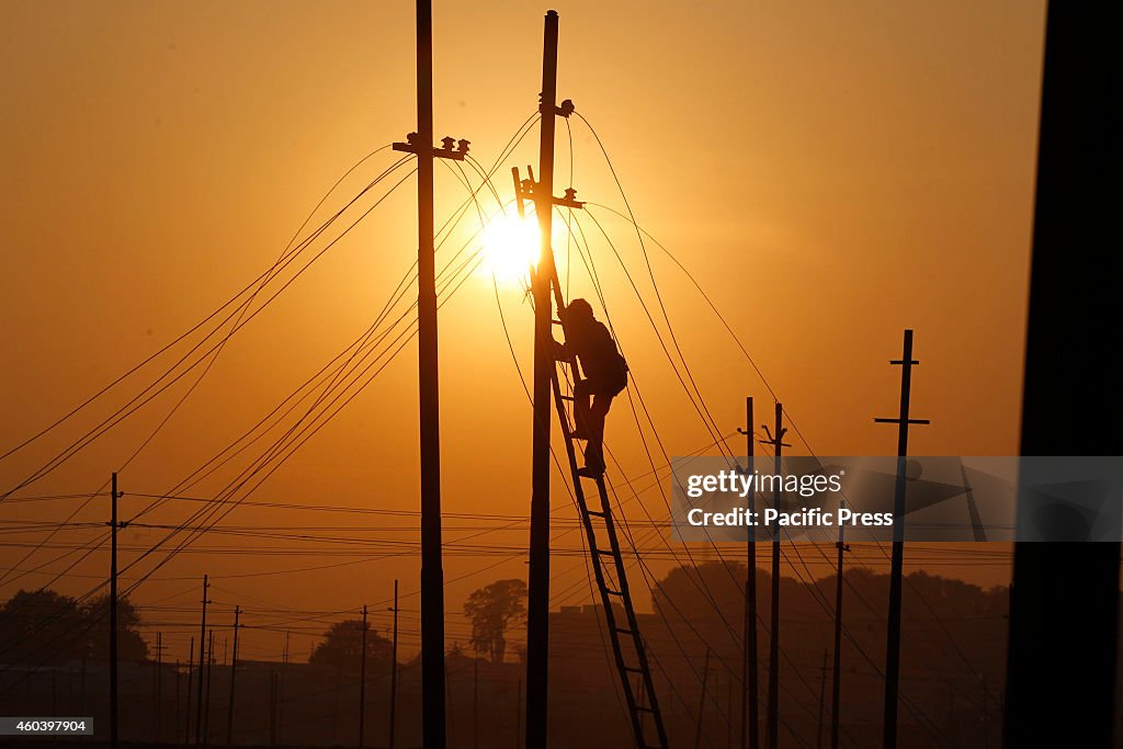 Workers install electric transformer on the river bank of...