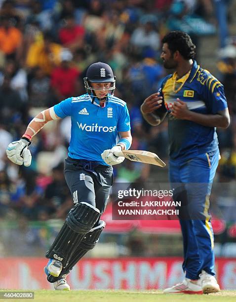 England cricketer Joe Root runs between wickets as Sri Lankan cricketer Thisara Perera looks on during the sixth One Day International match between...