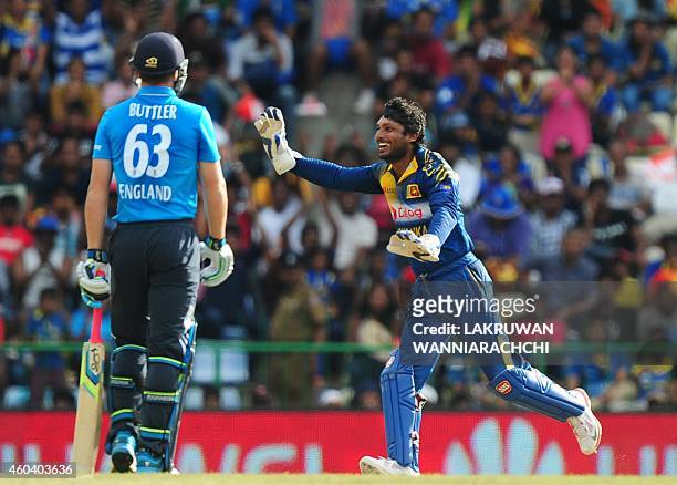 Sri Lankan wicketkeeper Kumar Sangakkara celebrates after dismissing England cricketer Jos Buttler during the sixth One Day International match...