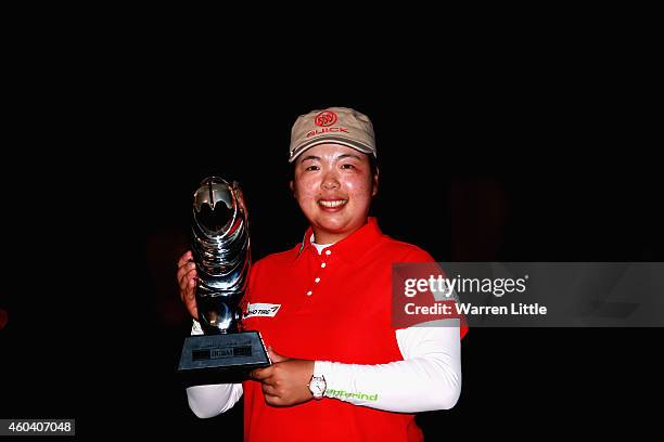 Shanshan Feng of China poses with the trophy after winning the Omega Dubai Ladies Masters on the Majlis Course at Emirates Golf Club on December 13,...