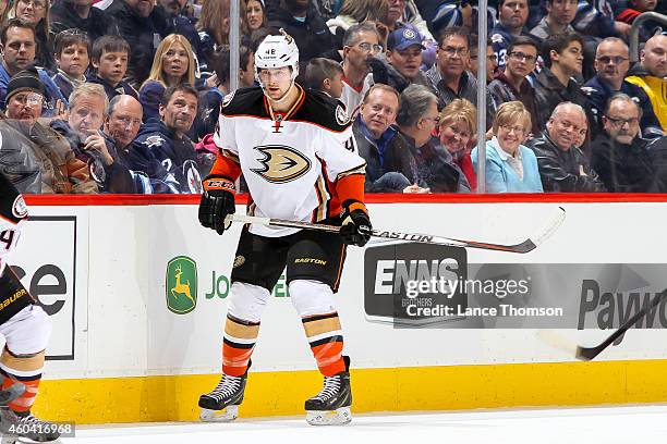 Colby Robak of the Anaheim Ducks keeps an eye on the play during first period action against the Winnipeg Jets on December 7, 2014 at the MTS Centre...