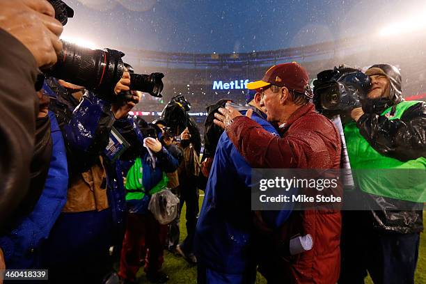 Head coach Tom Coughlin of the New York Giants and head coach Mike Shanahan of the Washington Redskins shake hands following the game at MetLife...