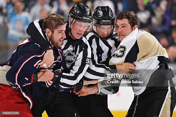 Linesmen David Brisebois and Bryan Pancich break up a fight between Brandon Dubinsky of the Columbus Blue Jackets and Steve Downie of the Pittsburgh...