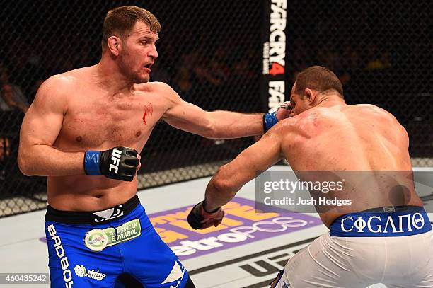 Stipe Miocic punches Junior Dos Santos of Brazil in their heavyweight fight during the UFC Fight Night event at the U.S. Airways Center on December...