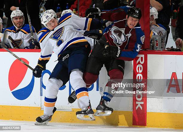 Ian Cole of the St. Louis Blues and Cody McLeod of the Colorado Avalanche collide as they pursue the puck at Pepsi Center on December 13, 2014 in...