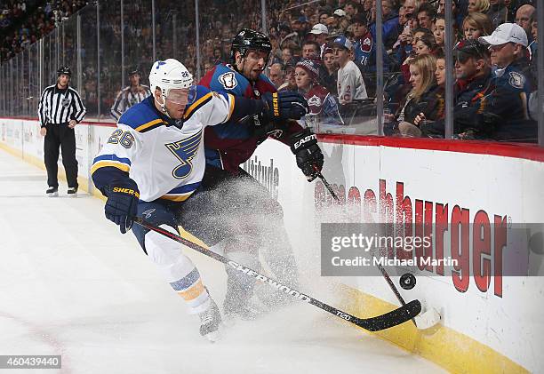 Paul Stastny of the St. Louis Blues battles for the puck against Nate Guenin of the Colorado Avalanche at the Pepsi Center on December 13, 2014 in...