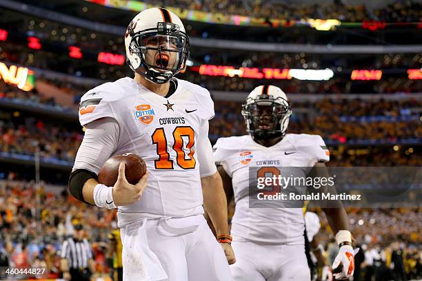 Quarterback Clint Chelf of the Oklahoma State Cowboys celebrates with Kye Staley after Chelf rushes for a 23-yard touchdown in the fourth quarter...