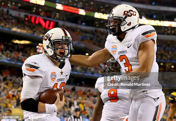 Quarterback Clint Chelf of the Oklahoma State Cowboys celebrates with Marcell Ateman after Chelf rushes for a 23-yard touchdown in the fourth quarter...