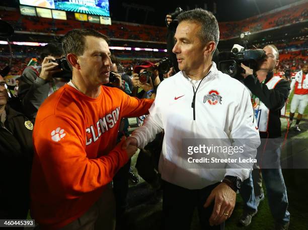 Head coach Dabo Swinney of the Clemson Tigers and head coach Urban Meyer of the Ohio State Buckeyes shake hands after the the Discover Orange Bowl at...