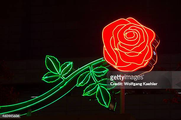 View of a colorful neon sign of a rose at night at the shore of the Willamette River in the city of Portland, Oregon, USA.
