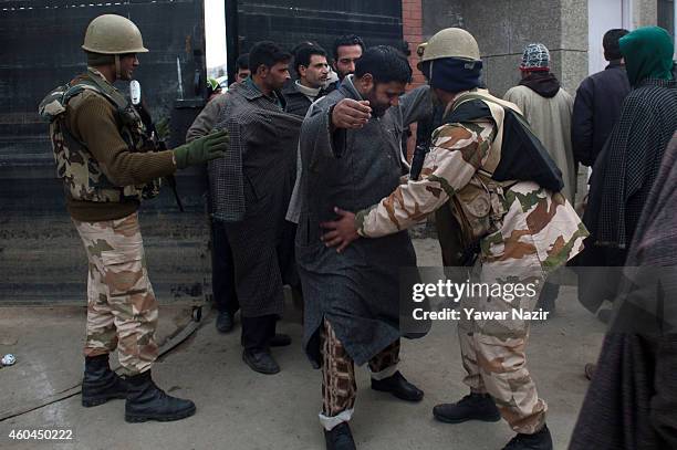 Indian government forces frisk Kashmiri voters before entering the polling station to cast their votes, during the fourth phase of assembly elections...