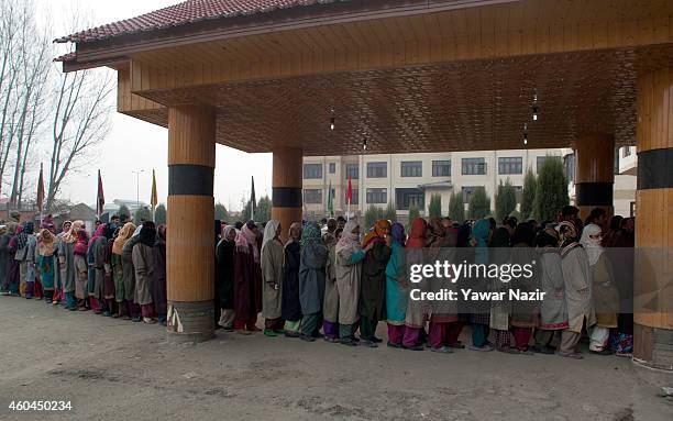 Kashmiri voters wait in queue to cast their votes outside the polling station, during the fourth phase of assembly elections on December 14, 2014 in...