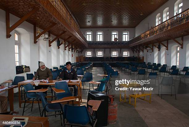 Polling officials wait for voters inside the deserted polling station in the Old City, during the fourth phase of assembly elections on December 14,...