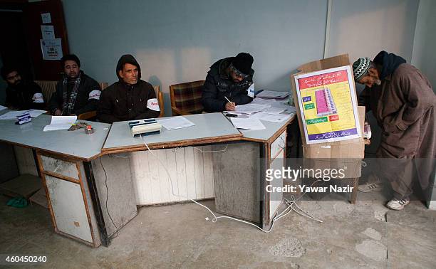 An elderly Kashmiri voter cast his vote inside the polling station, during the fourth phase of assembly elections on December 14, 2014 in Srinagar,...
