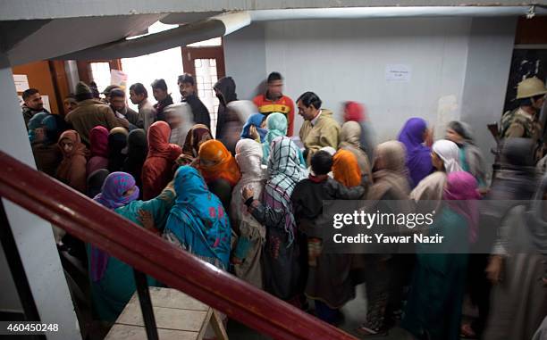 Kashmiri voters wait in queue to cast their votes outside the polling station, during the fourth phase of assembly elections on December 14, 2014 in...