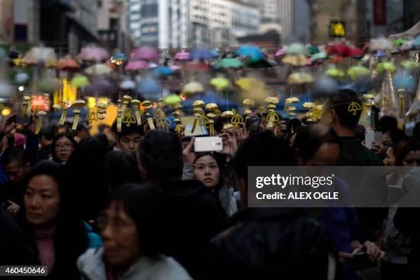 People take photos of an installation of paper umbrellas -- symbols of the pro-democracy protests in Hong Kong -- on a blockaded road in the Causeway...