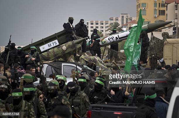 Palestinian militants of the Ezzedine al-Qassam Brigades, Hamas' armed wing, display Gaza Strip made M75 rockets during a parade marking the 27th...