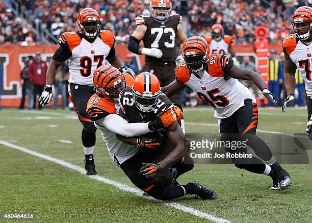 Josh Gordon of the Cleveland Browns gets tackled by Carlos Dunlap and Wallace Gilberry of the Cincinnati Bengals during the second quarter at...