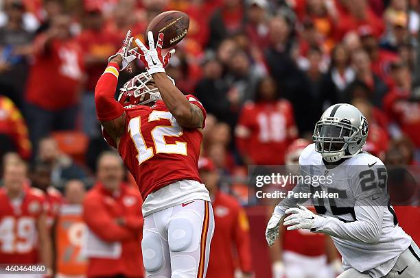 Albert Wilson of the Kansas City Chiefs completes a pass as D.J. Hayden of the Oakland Raiders defends in the first half at Arrowhead Stadium on...