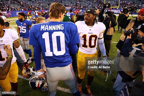 Eli Manning of the New York Giants talks with Robert Griffin III of the Washington Redskins after their game at MetLife Stadium on December 14, 2014...