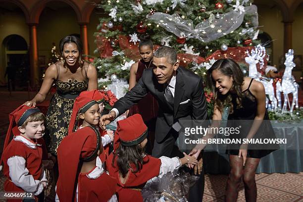 First Lady Michelle Obama , daughter Sasha Obama , US President Barack Obama and daughter Malia Obama greet children dressed as elves before the...